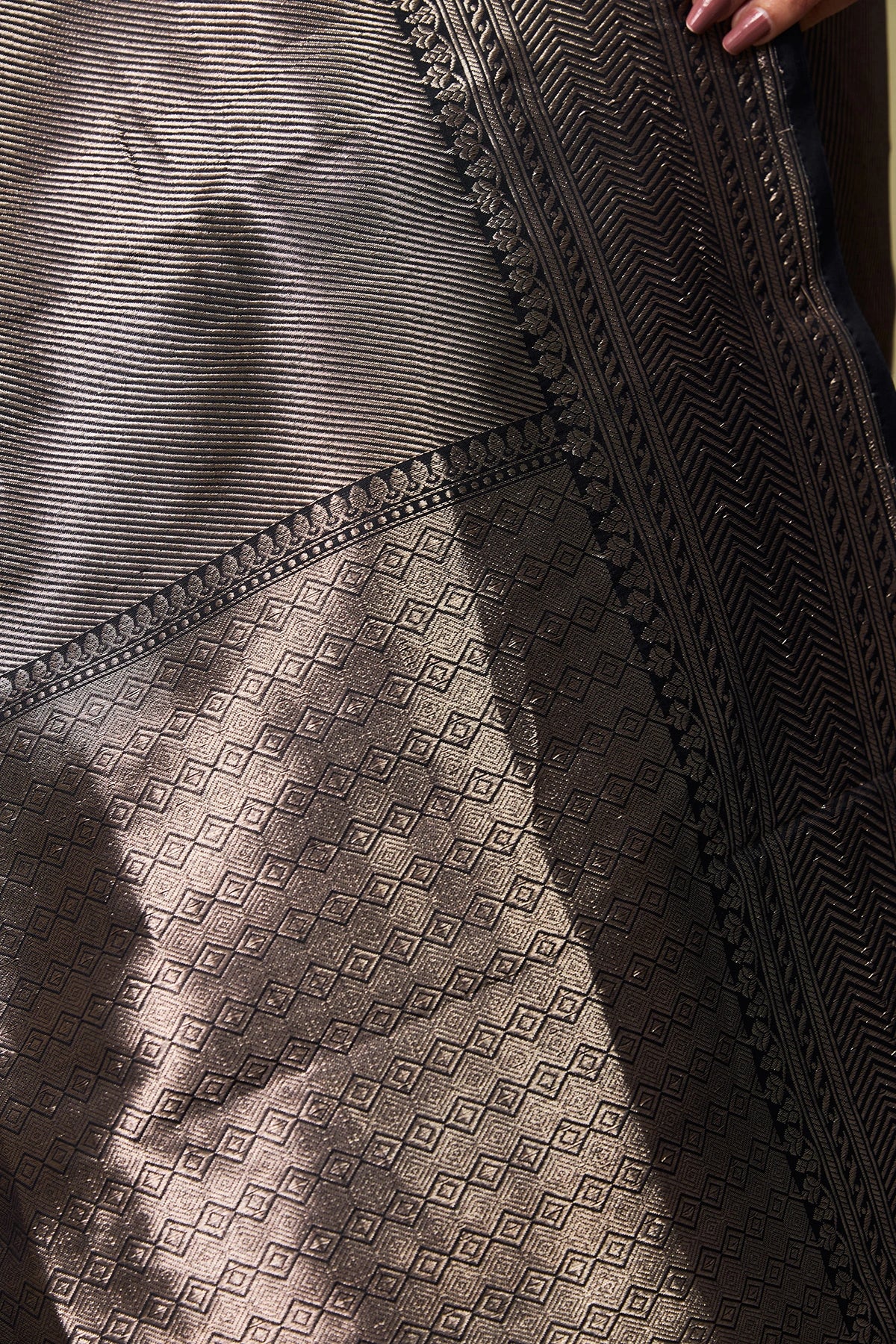 Detailed brocade weaving with chevron motifs on black silk fabric