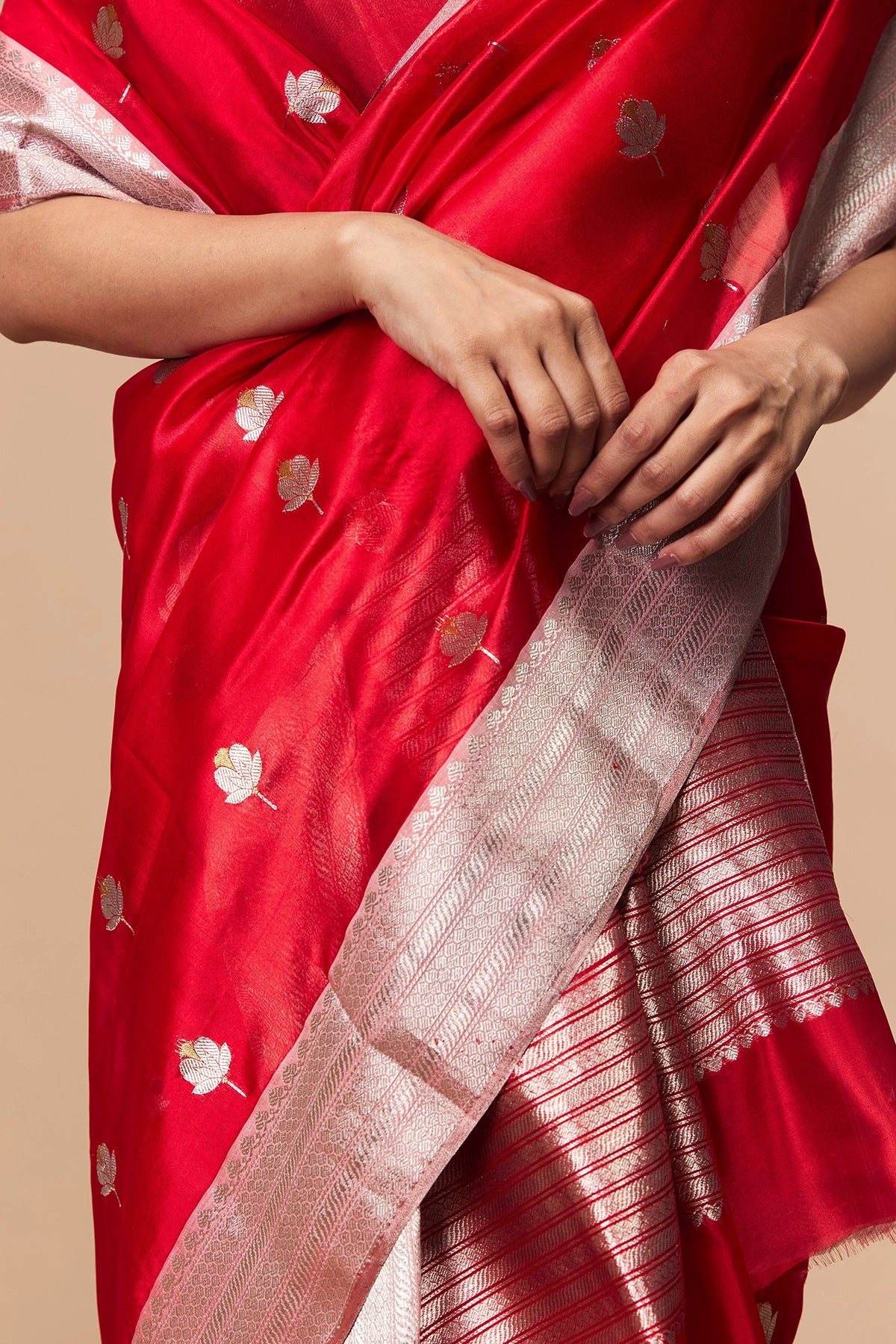 Close-up of floral silver zari motifs on red silk