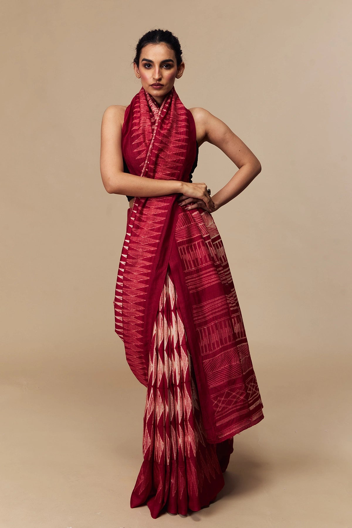 Model in cherry red Tussar silk saree with bold Shibori design