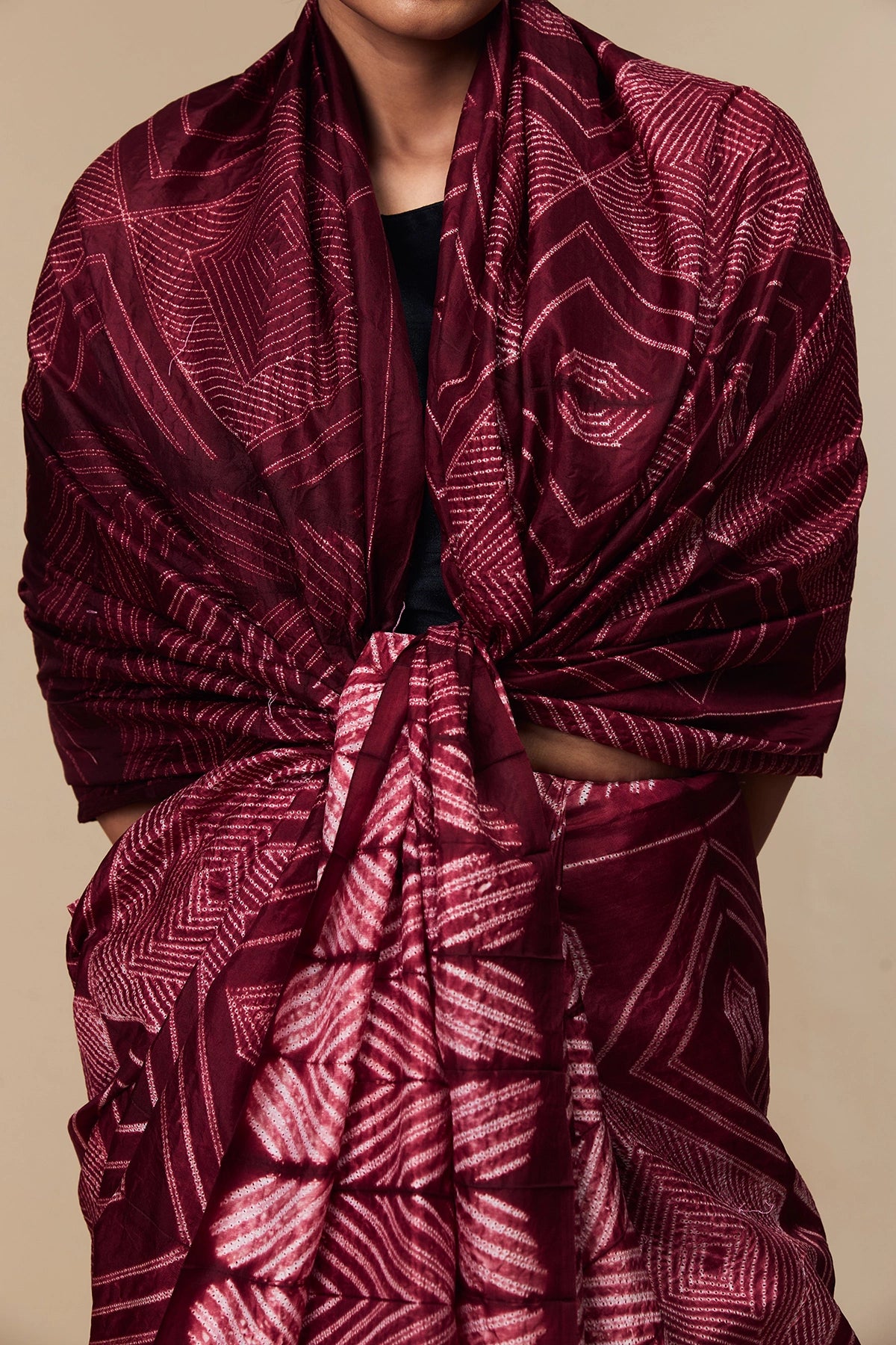 Close-up of concentric Shibori motifs on maroon silk fabric