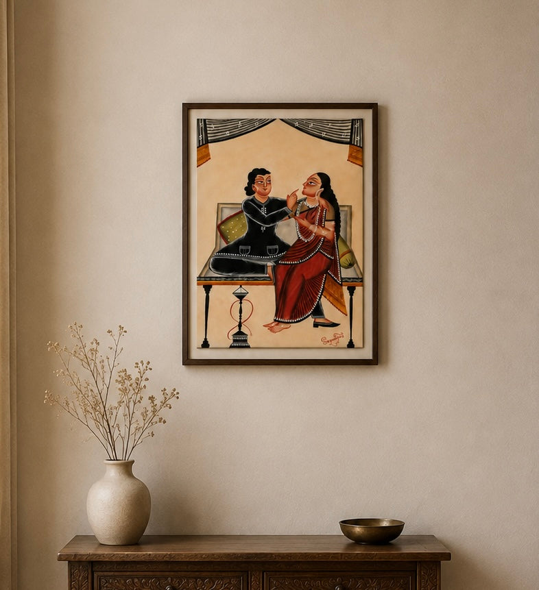 A framed art print depicting a traditional Indian scene with two figures, hung on a beige wall above a wooden console table with a vase and bowl.