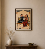 A framed art print depicting a traditional Indian scene with two figures, hung on a beige wall above a wooden console table with a vase and bowl.