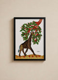A framed art print featuring a stylized giraffe beneath a tree with red berries, hung on a beige wall.