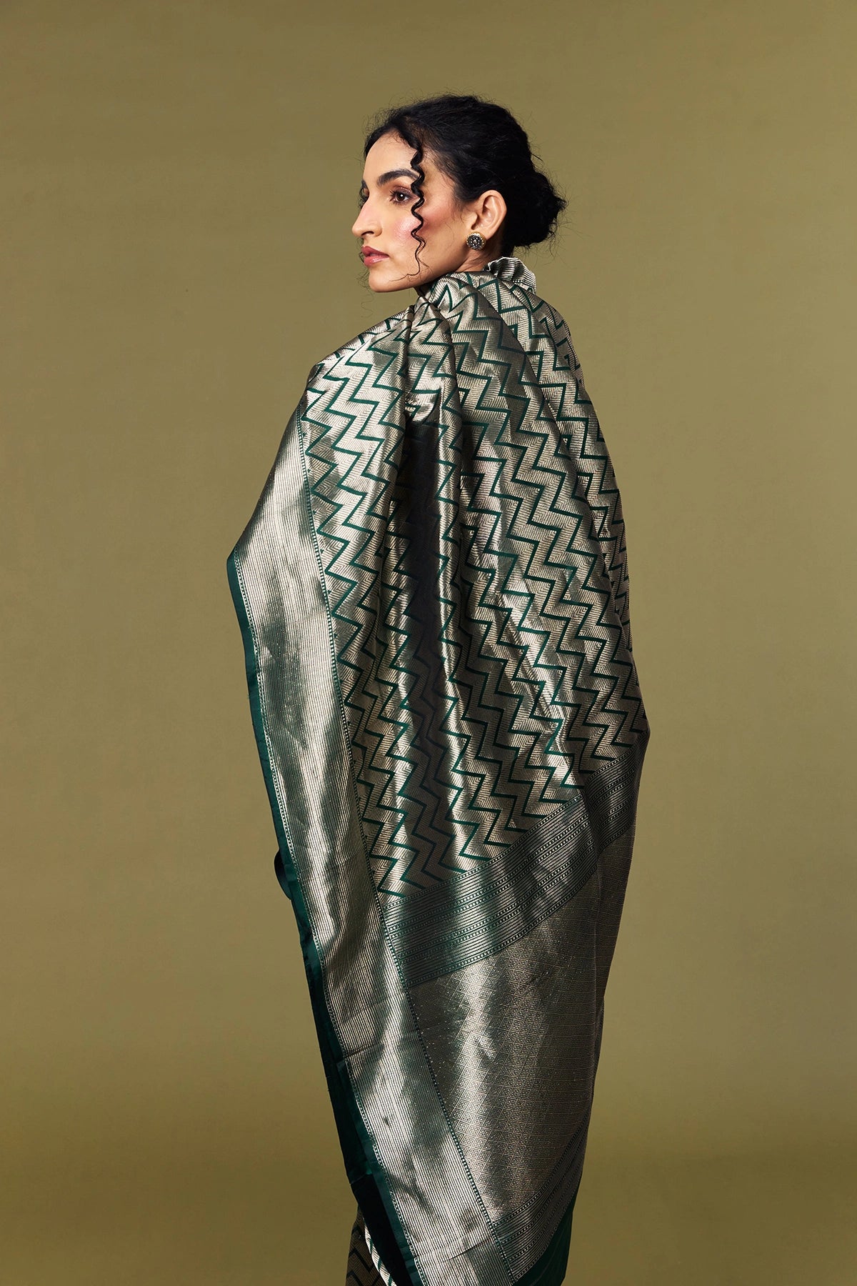 Model draped in emerald green Banarasi Katan silk saree with geometric zari pattern