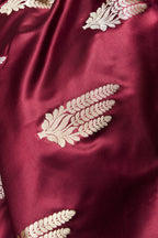 Detailed view of golden floral booti motifs woven across the body of the maroon Banarasi Mashru silk saree.