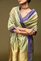 Close-up of woven floral motifs on pista green silk saree