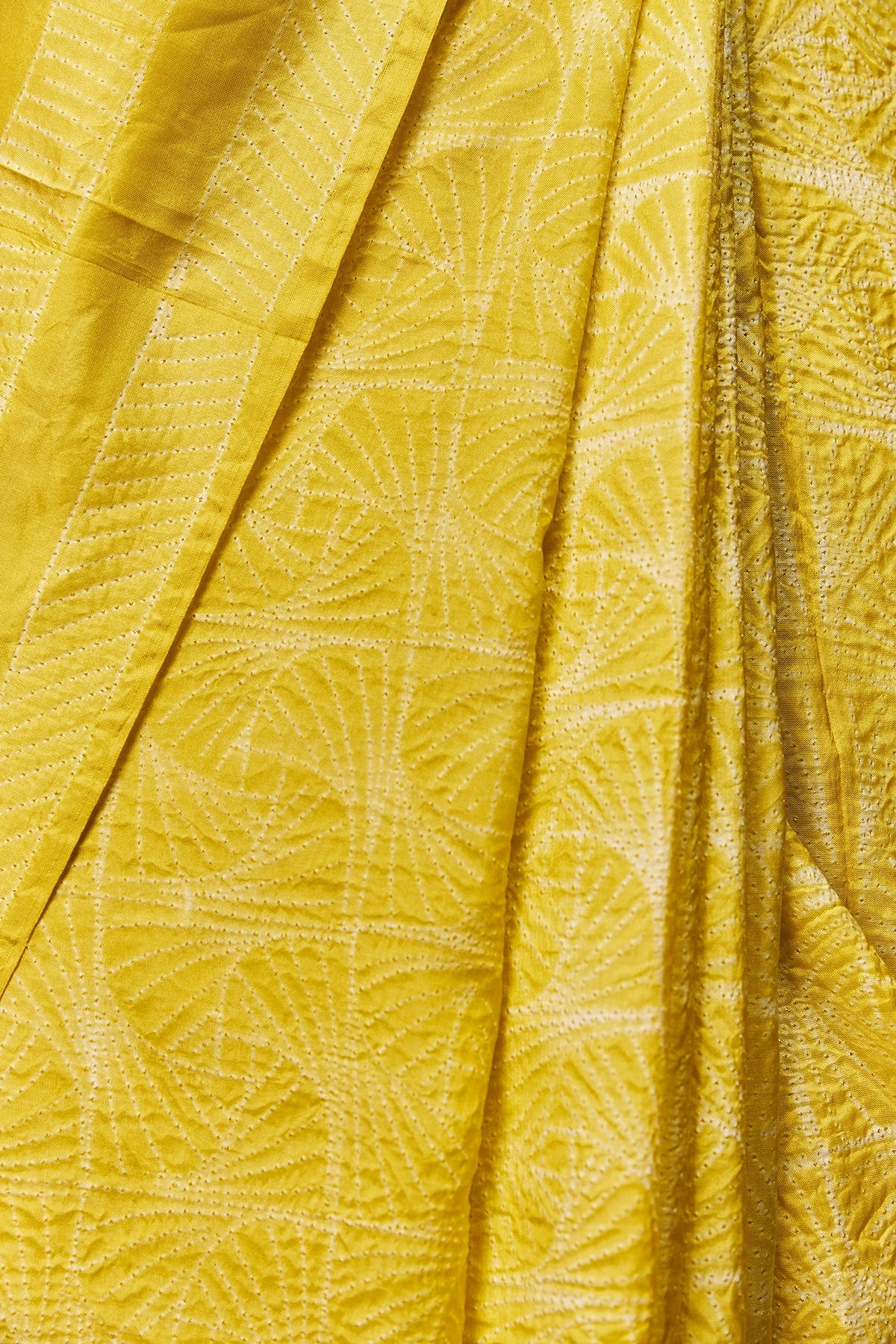 Pleated front of yellow saree with geometric motifs