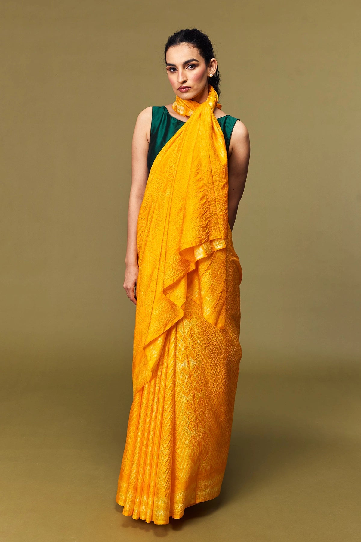 Front view of model in marigold orange Shibori silk saree