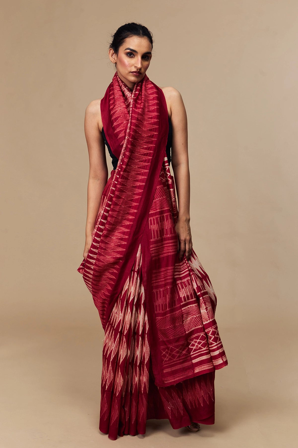 Model in cherry red Tussar silk saree with bold Shibori design